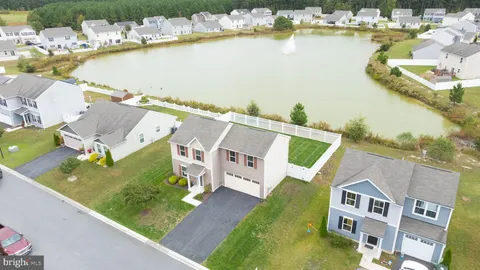 an aerial view of residential houses with outdoor space and ocean view