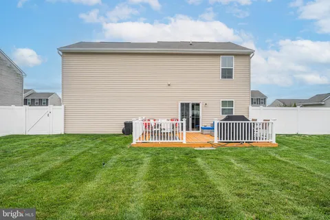 a view of a house with a yard and deck