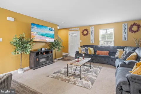a living room with furniture a flat screen tv and a large window