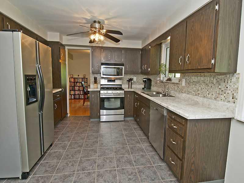 Kitchen. Gleaming Stainless Steel Appliances, Tile Back Splash & Access to Back Porch.