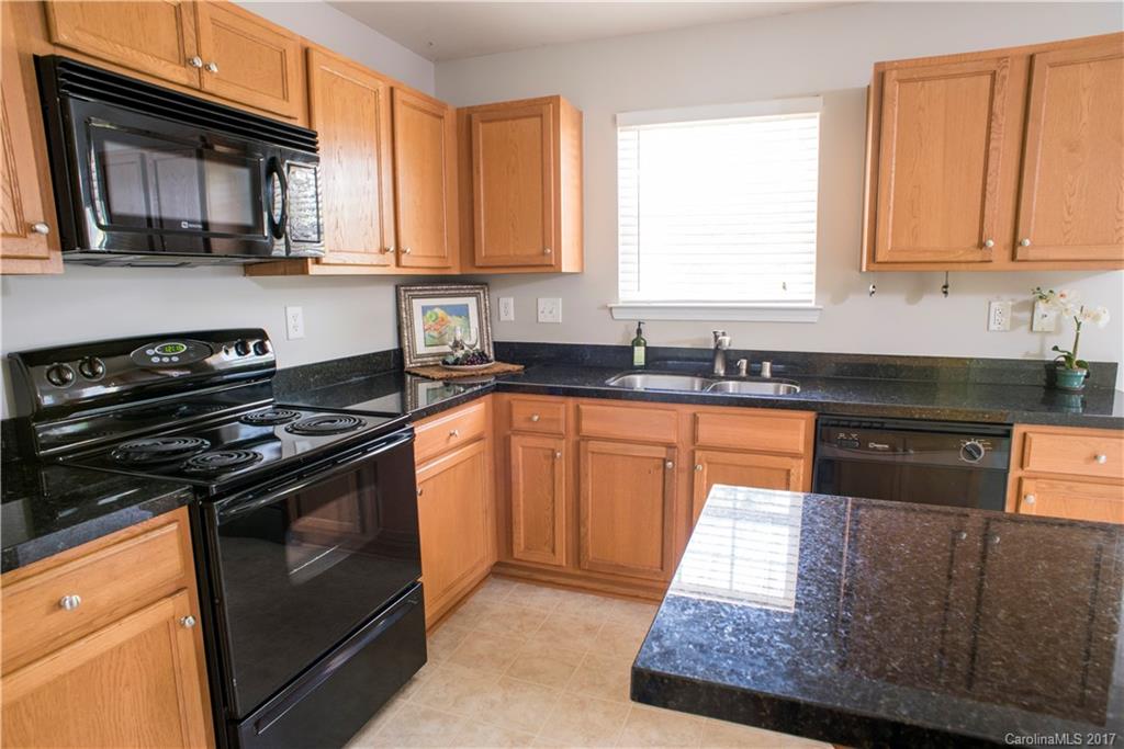 5207 Sunriver Road, Unit 52 Gastonia, NC 28054 - Photo 11 of 24 a kitchen with stainless steel appliances granite countertop a stove a sink and a microwave