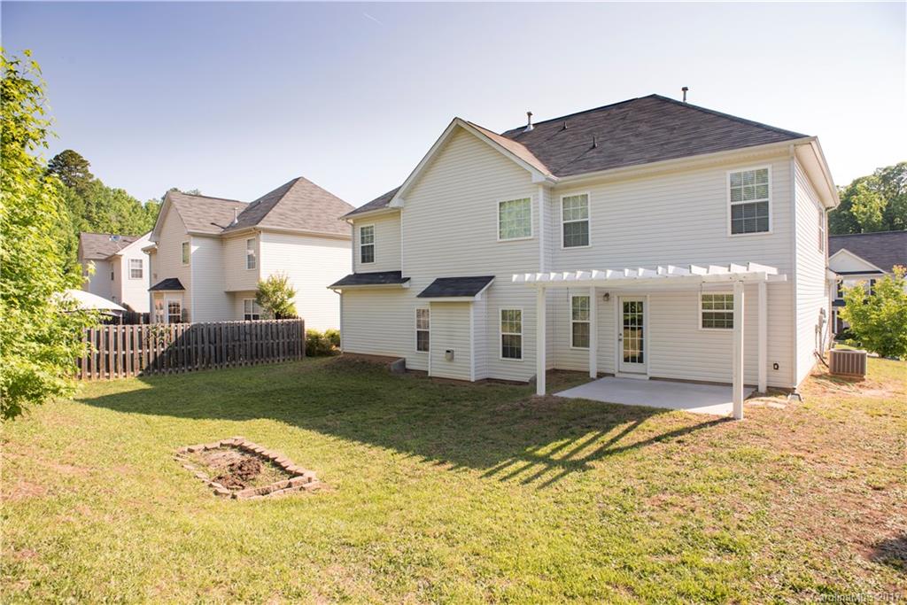 5207 Sunriver Road, Unit 52 Gastonia, NC 28054 - Photo 3 of 24 a view of a white house next to a yard with a big yard and large tree
