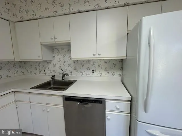 a kitchen with appliances a sink and cabinets