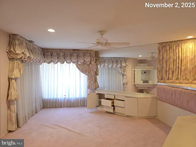 a view of an empty room with window and cabinet