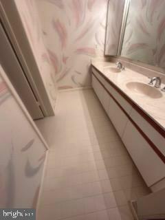 3031 Fallstaff Road, Unit 306C Baltimore, MD 21209 - Photo 21 of 23 a bathroom with a granite countertop sink and a mirror