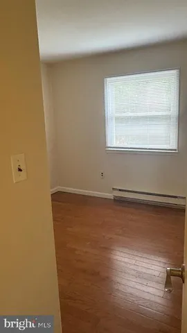 a view of a small space with wooden floor and a window