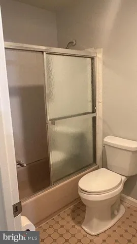 a white toilet sitting next to a shower
