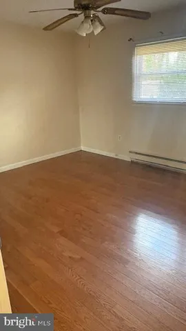 a view of a room with wooden floor and a window
