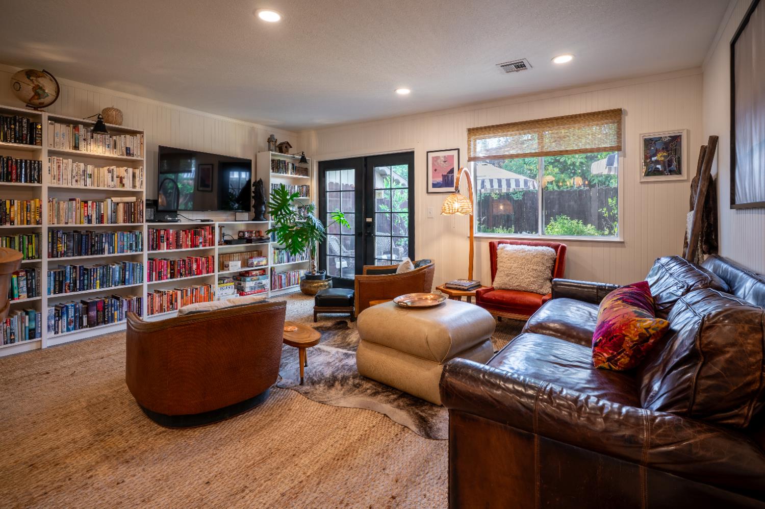 a living room with furniture a flat screen tv and a large window