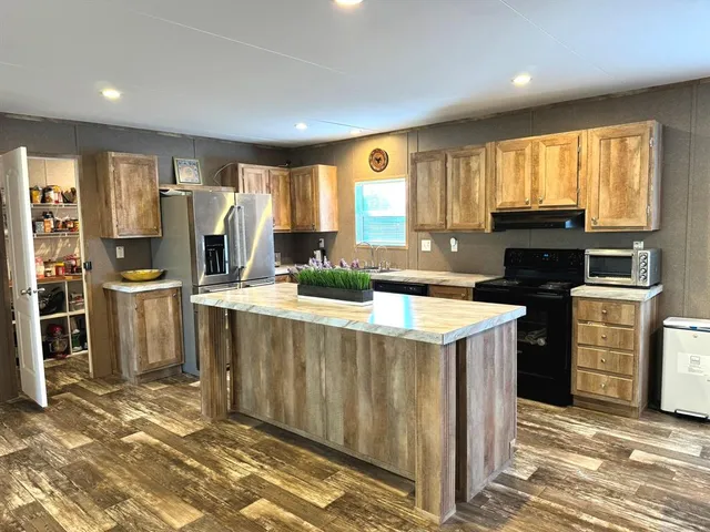 a kitchen with stainless steel appliances granite countertop a stove a sink and a refrigerator