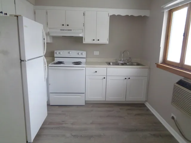 a kitchen with cabinets appliances a sink and a window