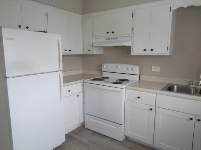 a kitchen with cabinets appliances a sink and a dishwasher