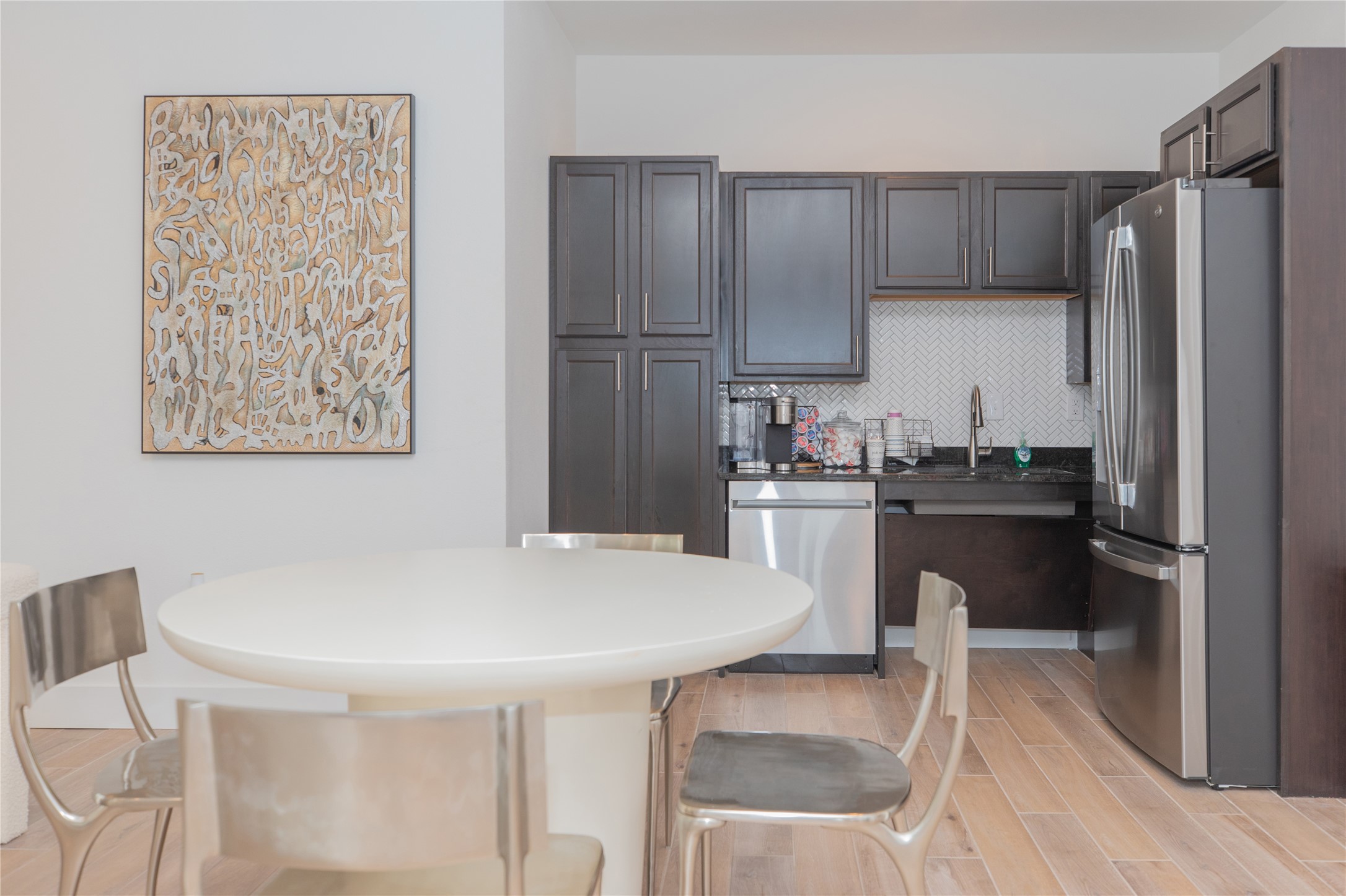 14809 Ralston Road, Unit A18302 Humble, TX 77396 - Photo 2 of 16 a kitchen with a table chairs refrigerator and cabinets