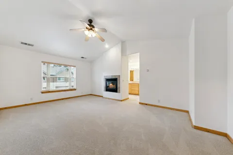 an empty room with fireplace and fan