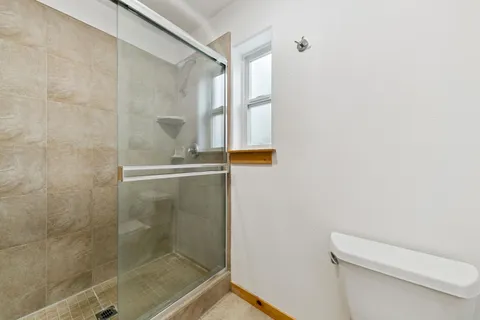 a spacious bathroom with a granite countertop sink a mirror and a shower