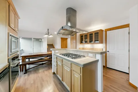 a kitchen with a stove and a wooden floor