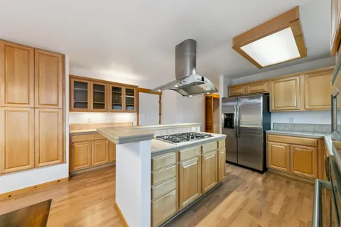 a kitchen with stainless steel appliances granite countertop a sink a stove and refrigerator