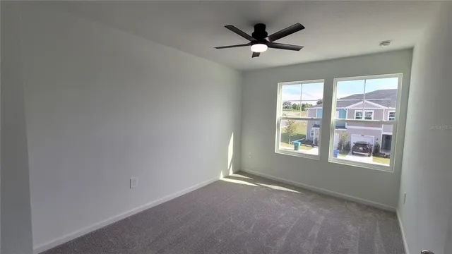 an empty room with a window and a fan