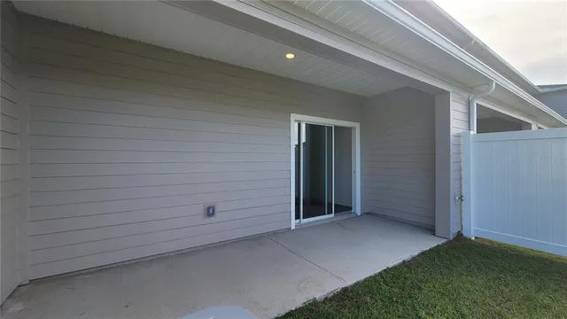 an empty room with a ceiling fan & cabinets