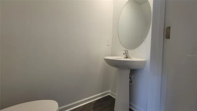a bathroom with a sink mirror and toilet