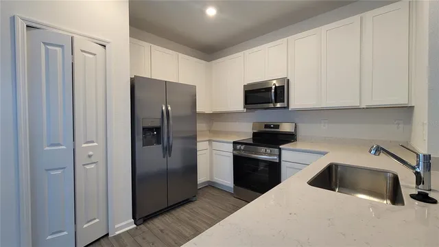 a kitchen with stainless steel appliances granite countertop a refrigerator and a stove top oven