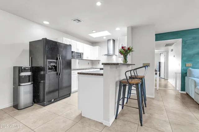 a spacious bathroom with a granite countertop sink and a mirror