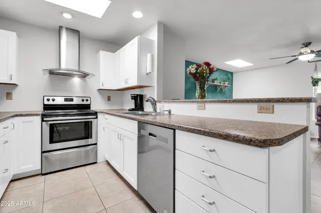a kitchen with granite countertop white cabinets stainless steel appliances and sink
