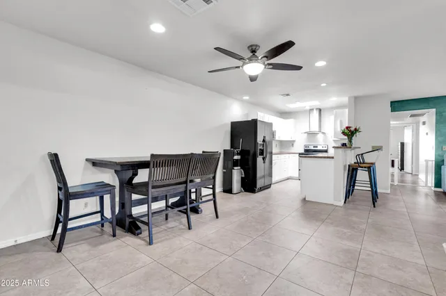 a view of a dining room with furniture and a chandelier fan