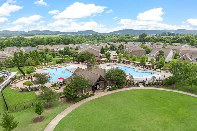 an aerial view of a house with a yard fire pit and outdoor seating