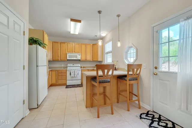 a kitchen with a refrigerator a counter space dining table and a window