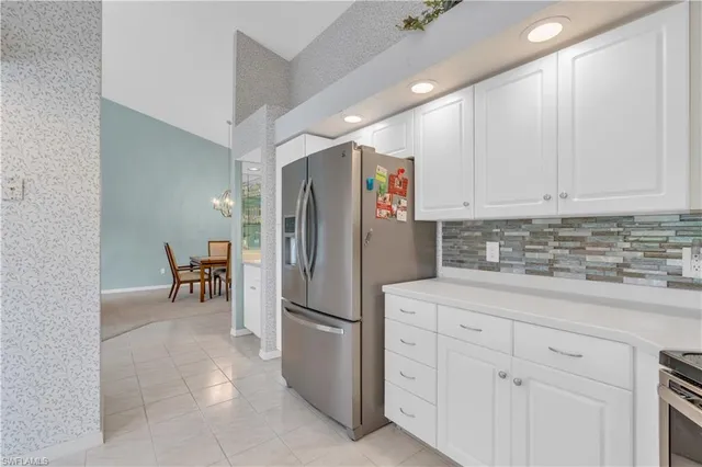 a kitchen with stainless steel appliances white cabinets and a refrigerator