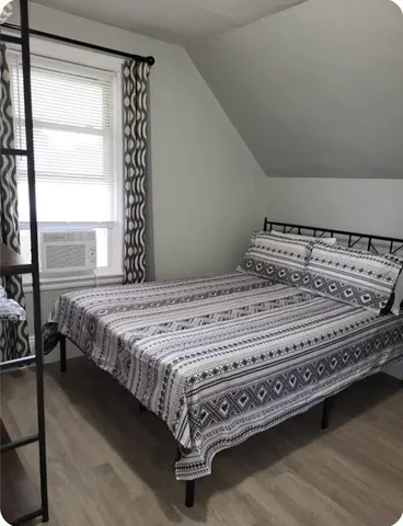 a bed sitting in a bedroom next to a window