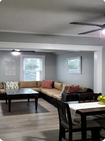 a living room with a table chairs and a window