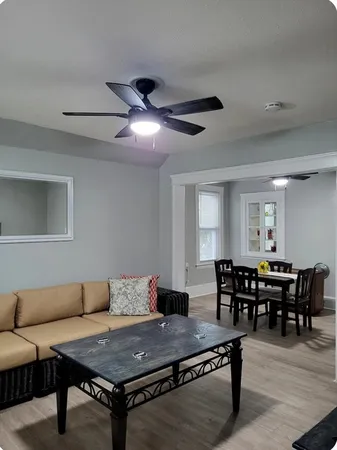 a living room with furniture a dining table and wooden floor
