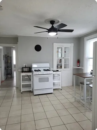 a kitchen with a stove cabinets and chairs