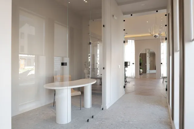 a view of a hallway with dining table and chairs