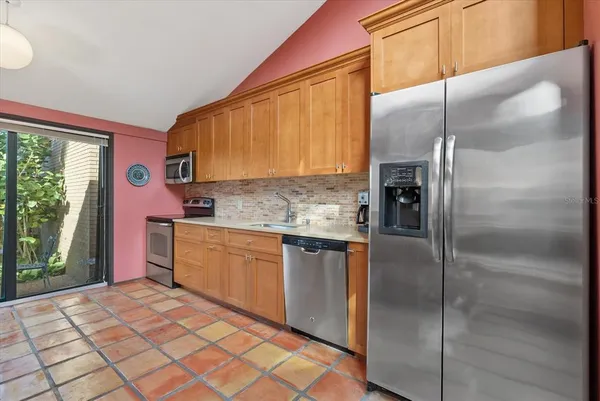 a kitchen with stainless steel appliances granite countertop a refrigerator and a sink