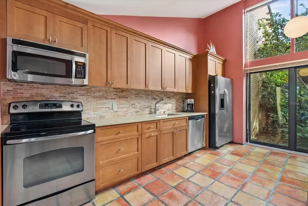 a kitchen with stainless steel appliances granite countertop a stove top oven microwave and refrigerator