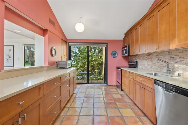 a large kitchen with stainless steel appliances granite countertop a stove a sink and a microwave