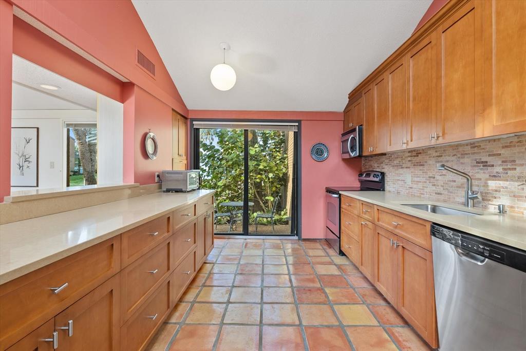 35 Sandy Cove Road, Unit 2A Sarasota, FL 34242 - Photo 16 of 49 a large kitchen with stainless steel appliances granite countertop a stove a sink and a microwave