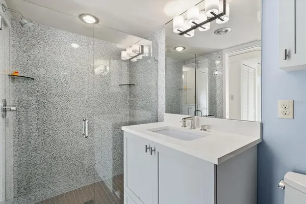 a bathroom with a sink a mirror and shower