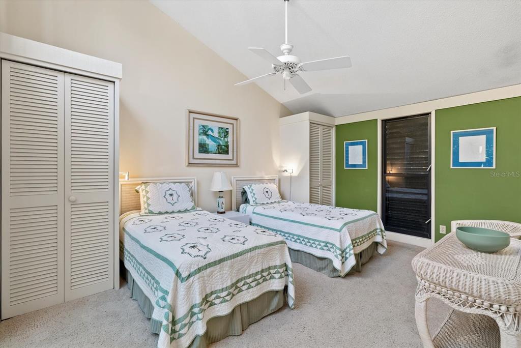 35 Sandy Cove Road, Unit 2A Sarasota, FL 34242 - Photo 27 of 49 a bedroom with two beds and a chandelier