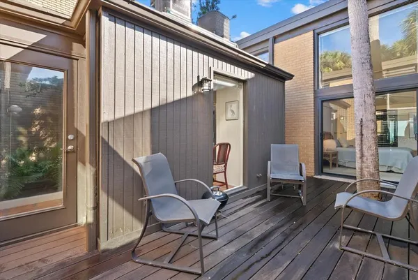 a balcony with wooden floor and outdoor seating