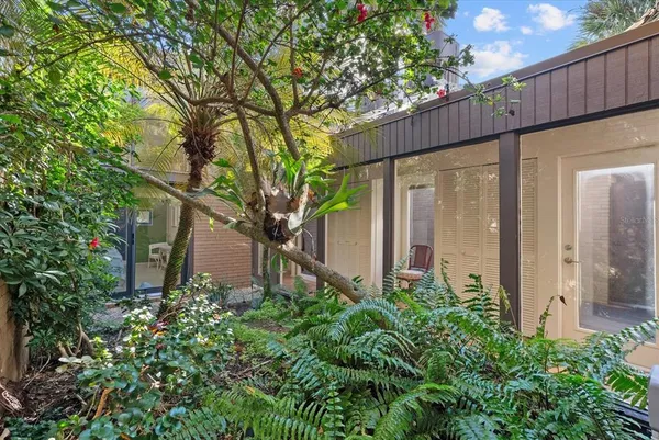 a view of a house with a large windows and plants