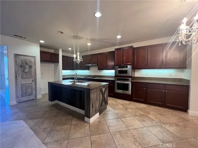 a kitchen with kitchen island granite countertop wooden cabinets and stainless steel appliances
