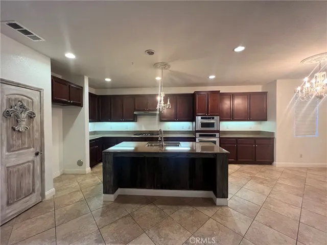 a kitchen with stainless steel appliances granite countertop a stove a sink and a refrigerator