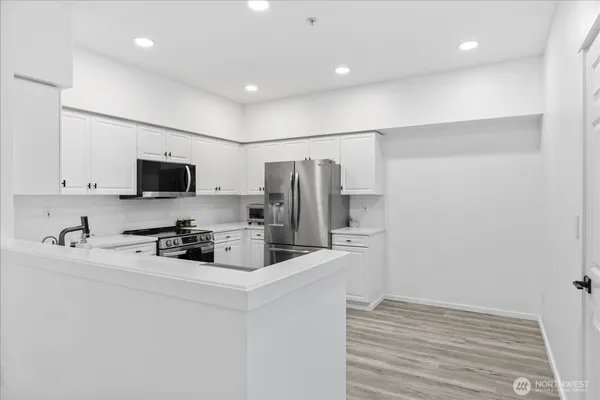 a kitchen with stainless steel appliances a refrigerator stove microwave and sink