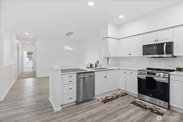 a kitchen with granite countertop a stove top oven sink and cabinets