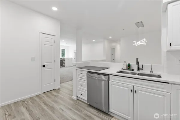 a kitchen with a sink cabinets and wooden floor