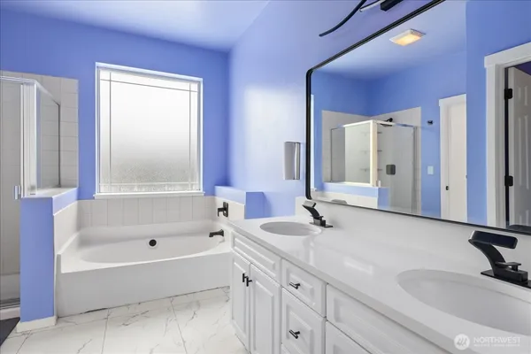 a bathroom with a tub sink and mirror